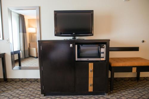 a flat screen tv sitting on top of a entertainment center at Holiday Inn Express Hotel & Suites Chanhassen by IHG in Chanhassen