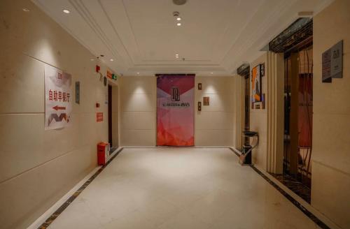 a hallway with a red door in a building at Baoli International Hotel - Yangjiang Baili Plaza in Yangjiang
