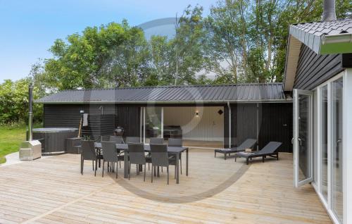 a patio with a table and chairs on a deck at Gorgeous Home In Spøttrup With Sauna in Vester Lem