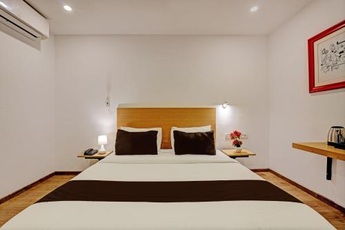 a bedroom with a large bed in a room at Super Townhouse Ramamurthy Nagar Formerly Navya International in Bengaluru