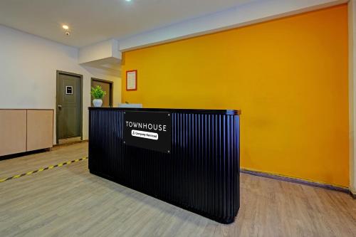 a room with a yellow wall and a black fence at Super Townhouse Ramamurthy Nagar Formerly Navya International in Bengaluru
