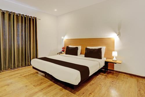 a bedroom with a large bed and a large window at Super Townhouse Ramamurthy Nagar Formerly Navya International in Bengaluru