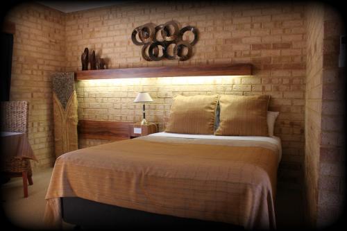 um quarto com uma cama grande e uma parede de tijolos em York's Boutique Motel em York