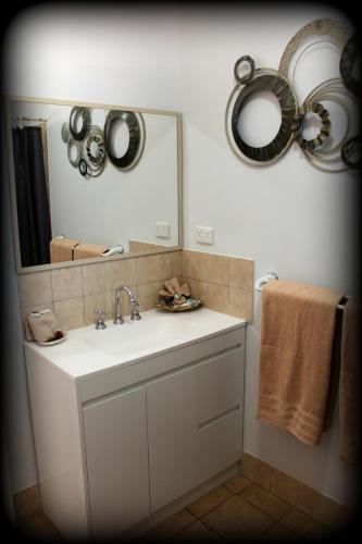 a bathroom with a sink and a mirror and towels at York's Boutique Motel in York