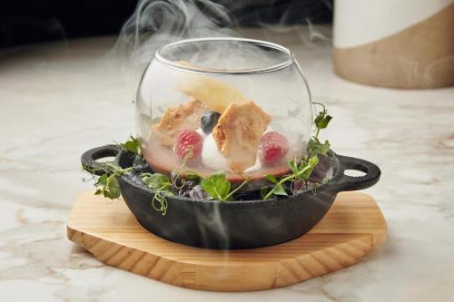 a glass bowl with food in it on a table at Andaz Capital Gate Abu Dhabi, By Hyatt in Abu Dhabi