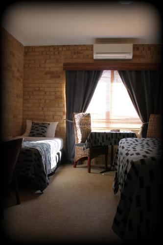 a bedroom with two beds and a window at York's Boutique Motel in York