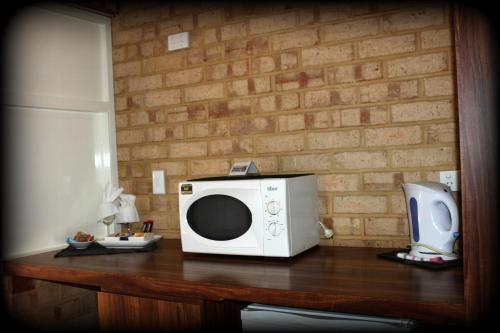 a microwave sitting on a table next to a refrigerator at York's Boutique Motel in York