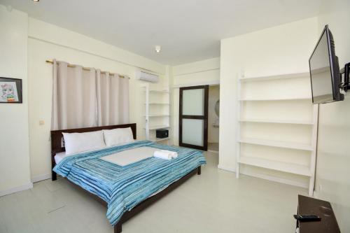 a bedroom with a bed with white walls and shelves at Babosam Apartments in Boracay