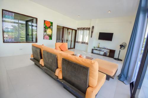 a living room with a couch and a television at Babosam Apartments in Boracay
