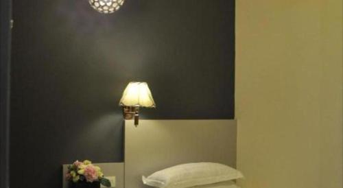 a bedroom with a bed with a lamp on the wall at In Trend Hotel in Cukai