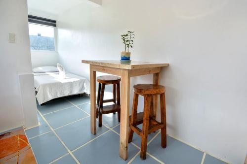 a table and two stools in a room with a bed at Babosam Apartments in Boracay