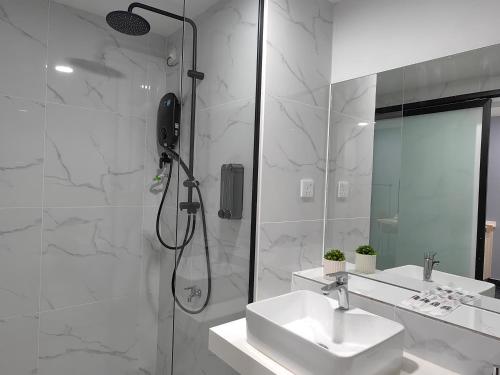 a white bathroom with a shower and a sink at Vetro11 Beside QEH1 by JUNE Homestay in Kota Kinabalu