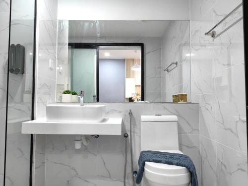 a bathroom with a sink and a toilet and a mirror at Vetro11 Beside QEH1 by JUNE Homestay in Kota Kinabalu