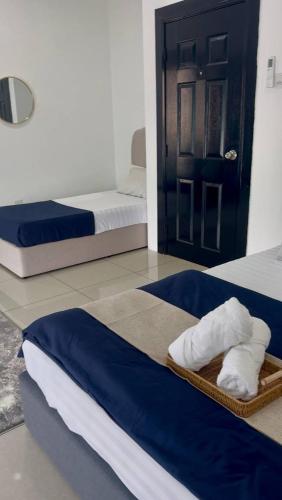 a room with two beds and a door with towels at AL Rayyan Homestay KLIA SEPANG in Sepang