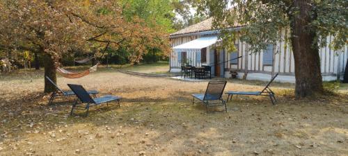 a group of chairs and a hammock in front of a house at Riban in Sabres