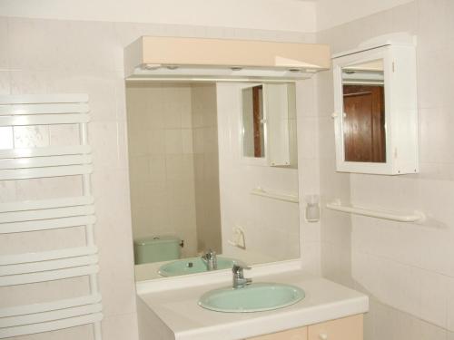 a white bathroom with a sink and a mirror at Bergerie " Le Cortal " in Nohèdes