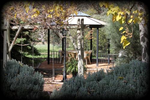 a gazebo with a table in a garden at York's Boutique Motel in York