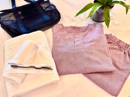 a pair of pants and a pair of scissors on a table at HOTEL minimumms女性専用カプセルホテルWomen only hotel in Naha