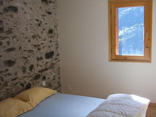a bed in a bedroom with a window at Bergerie " Le Cortal " in Nohèdes