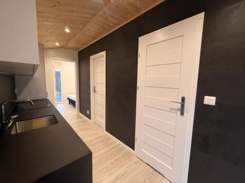 a kitchen with a white door and a black wall at Holiday accommodation in the middle of nature in Knared in Eslared