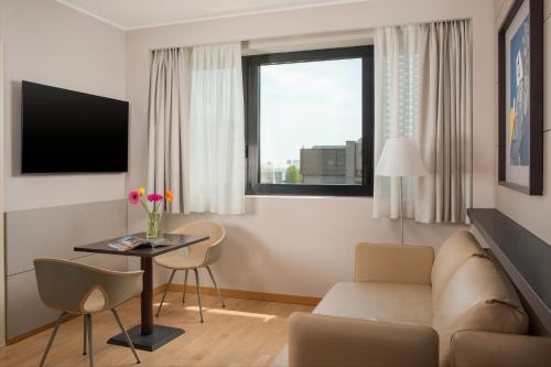 a living room with a couch and a table at UNA Hotels Bologna Fiera in Bologna