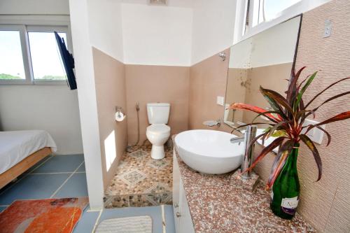 a bathroom with a tub and a toilet and a plant at Babosam Apartments in Boracay