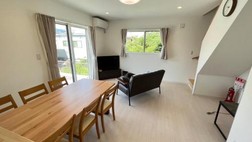 a living room with a wooden table and a chair at Villa ANOTONA No,2 - Vacation STAY 15168 in Fujikawaguchiko