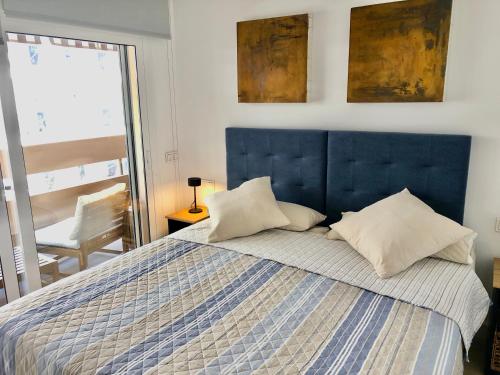 Bett mit blauem Kopfteil und 2 Kissen in der Unterkunft Esperanza Grand Apartments - Marbella Centro in Marbella