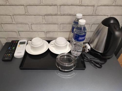 a black tray with cups and plates and water bottles at Hotel 99 Seri Kembangan Serdang in Seri Kembangan