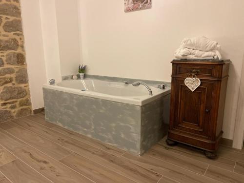 a bath tub in a bathroom with a wooden cabinet at Locanda Vecchio Caseificio in Toano