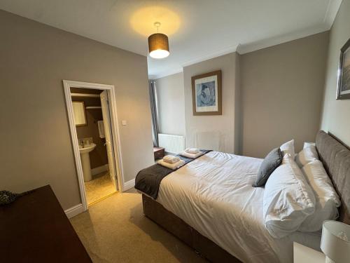 a bedroom with a bed and a hallway with a bathroom at The Links House Lytham St Annes in Lytham St Annes