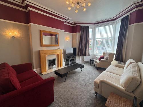 a living room with two couches and a fireplace at The Links House Lytham St Annes in Lytham St Annes