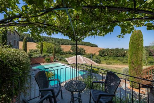 a patio with a table and chairs next to a pool at Mas Combefa in Combefa