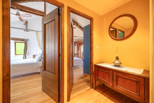 a bathroom with a vanity and a mirror and a bedroom at Mas Combefa in Combefa