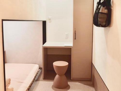 a small bathroom with a toilet and a sink at HOTEL minimumms女性専用カプセルホテルWomen only hotel in Naha