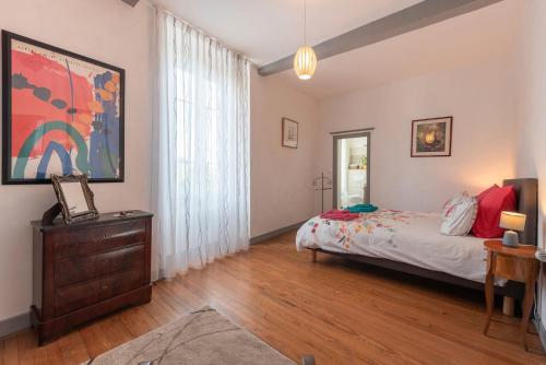 a bedroom with a bed and a dresser and a window at Chambres D'hôtes Maison Galouÿe in Montgaillard