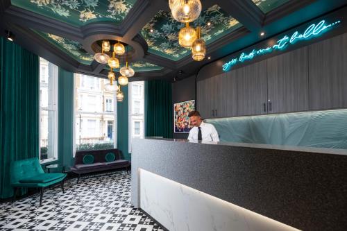 a man standing behind a counter in a restaurant at Brit Hotels Earls Court in London