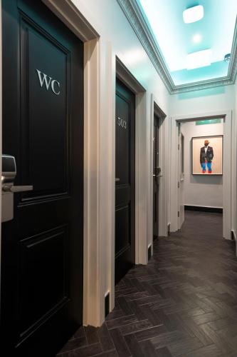 a hallway of a hotel with black doors at Brit Hotels Earls Court in London