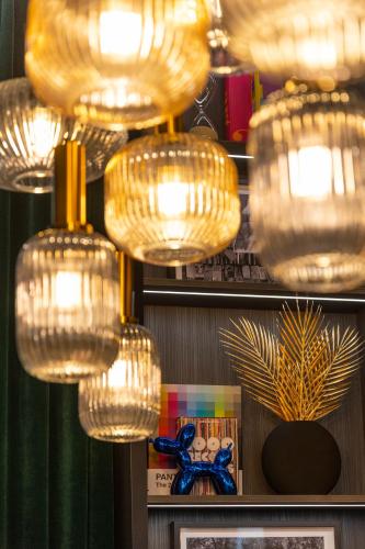 a group of glass chandeliers hanging in a room at Brit Hotels Earls Court in London