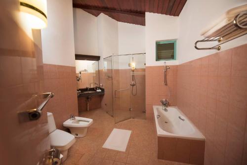 a bathroom with a shower and a toilet and a sink at Mandara Rosen Yala, Kataragama in Kataragama