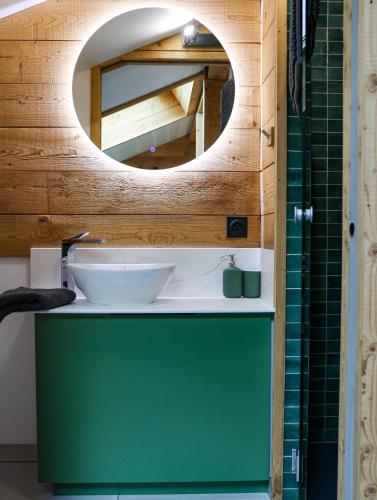 a bathroom with a green sink and a mirror at Genepi loft duplex 4 personnes in Arâches-la-Frasse