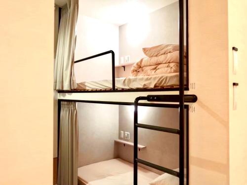 a bunk bed in a small room with a bunk bedutenewayangering at HOTEL minimumms女性専用カプセルホテルWomen only hotel in Naha