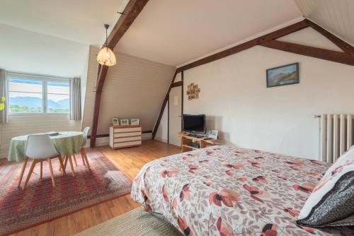 a bedroom with a bed and a table and a television at Chambres D'hôtes Maison Galouÿe in Montgaillard
