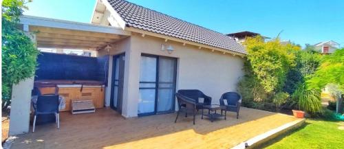 a house with a deck with chairs and a table at Luna Bianca in Had Nes