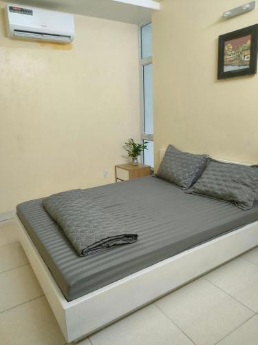 a bed in a white room with avertisementatronatronstrationstrationstration at Nhật Minh Motel Hải Phòng in Hai Phong