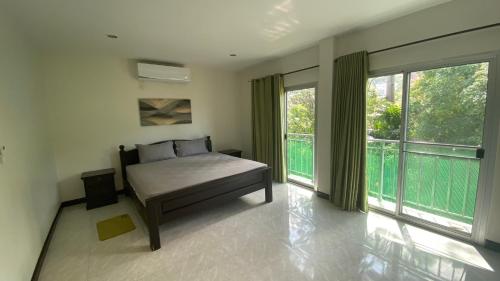 a bedroom with a bed and a large window at Green orchid Apartment in Mae Nam