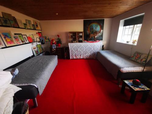 a bedroom with two beds and a red carpet at Den gamle smedie in Holbæk