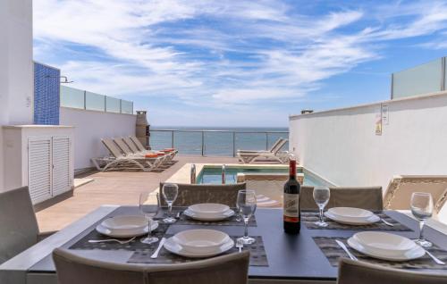 una mesa de comedor con una botella de vino en el balcón en Amazing Home In Torrox Costa, en Torrox Costa