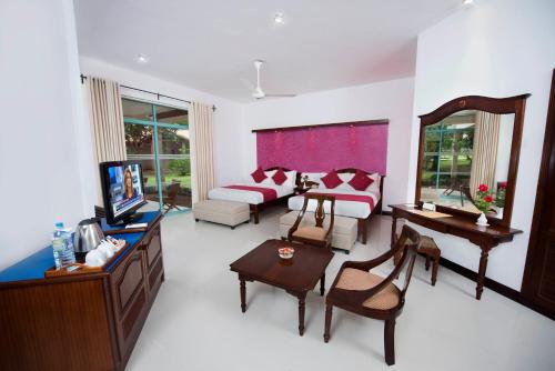 a living room with a couch and a tv at Mandara Rosen Yala, Kataragama in Kataragama