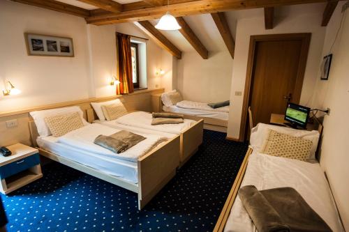 pokój z dwoma łóżkami i telewizorem w obiekcie B&B Col Da La Vila w mieście Canazei